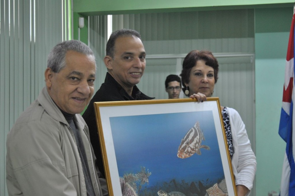 Antonio Guerrero haciendo entrega de una de las pinturas al director del Acuario Nacional, con 50 desde su apertura como centro de educación ambiental.