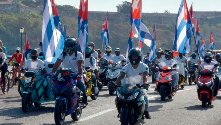 Motociclistas circulan ondeando banderas cubana mientras recorren el emblemáticos Malecón de La Habana en una singular caravana que demandó el fin del bloqueo que desde hace más de medio siglo mantiene Estados Unidos contra la isla, en La Habana, el 28 de marzo de 2021. Foto: Joaquín Hernández Mena/Trabajadores