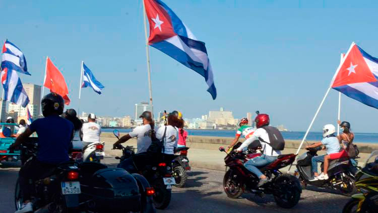 Motociclistas circulan ondeando banderas cubana mientras recorren el emblemáticos Malecón de La Habana en una singular caravana que demandó el fin del bloqueo que desde hace más de medio siglo mantiene Estados Unidos contra la isla, en La Habana, el 28 de marzo de 2021. Foto: Joaquín Hernández Mena/Trabajadores